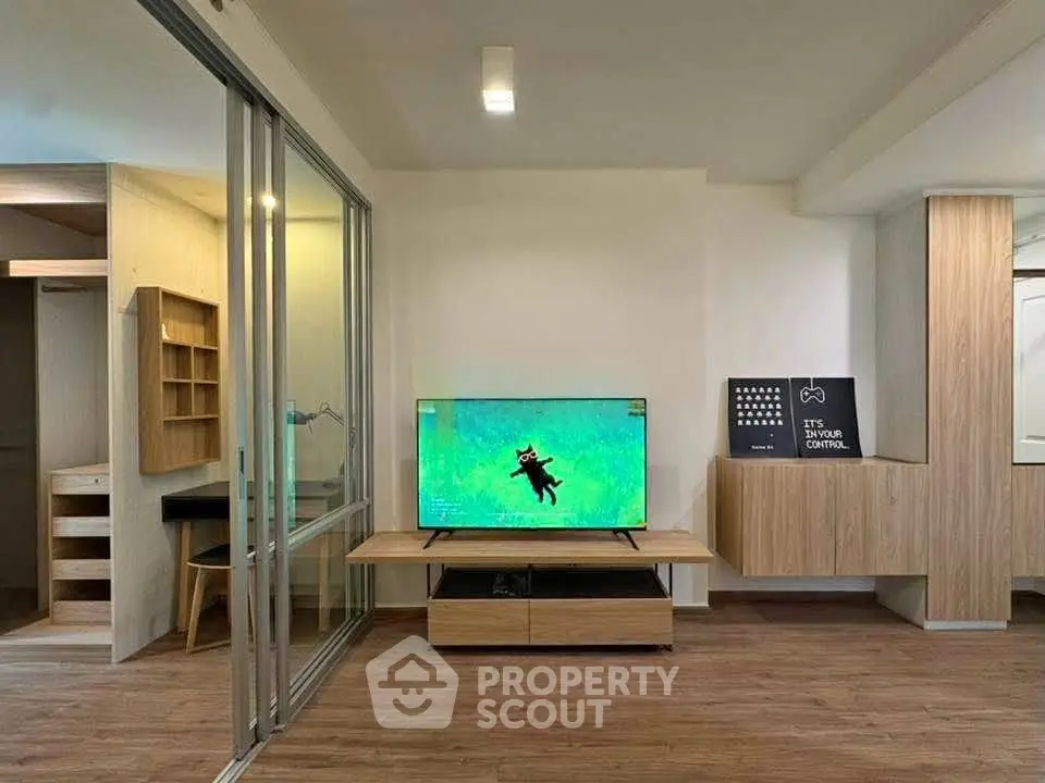 Modern living room with sleek wooden furniture and a large TV, perfect for relaxation and entertainment.