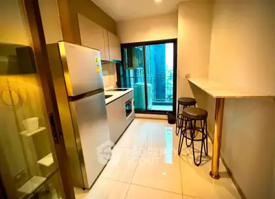 Modern kitchen with sleek appliances and breakfast bar, featuring a balcony view.