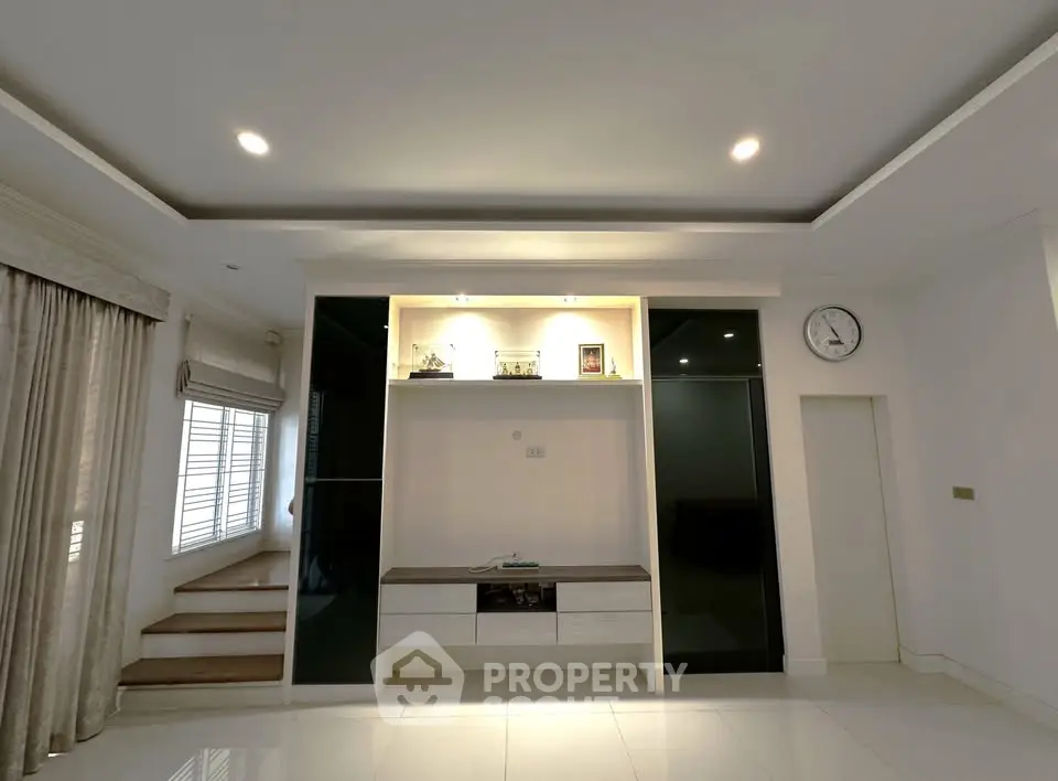 Spacious modern living room with elegant lighting and sleek built-in storage.