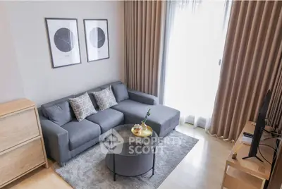 Modern living room with stylish gray sofa, glass coffee table, and elegant decor.