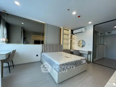 Modern bedroom with stylish decor and large mirror in a contemporary apartment.