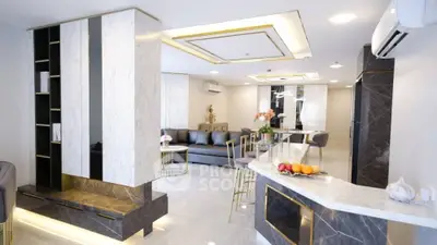 Luxurious modern living room with elegant marble accents and stylish open layout.