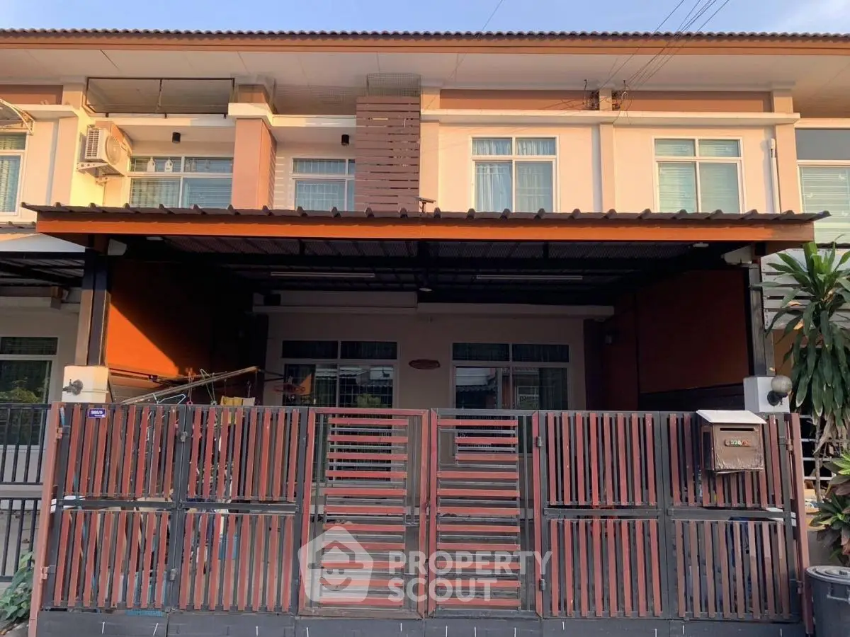 Charming two-story townhouse with modern facade and gated entrance