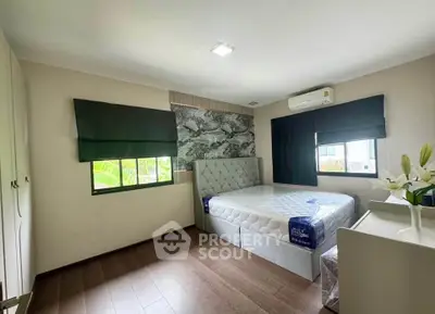 Modern bedroom with stylish decor and natural light, featuring a comfortable bed and elegant furnishings.