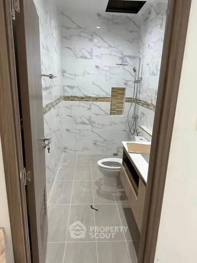 Modern bathroom with marble tiles and sleek fixtures in a contemporary apartment.