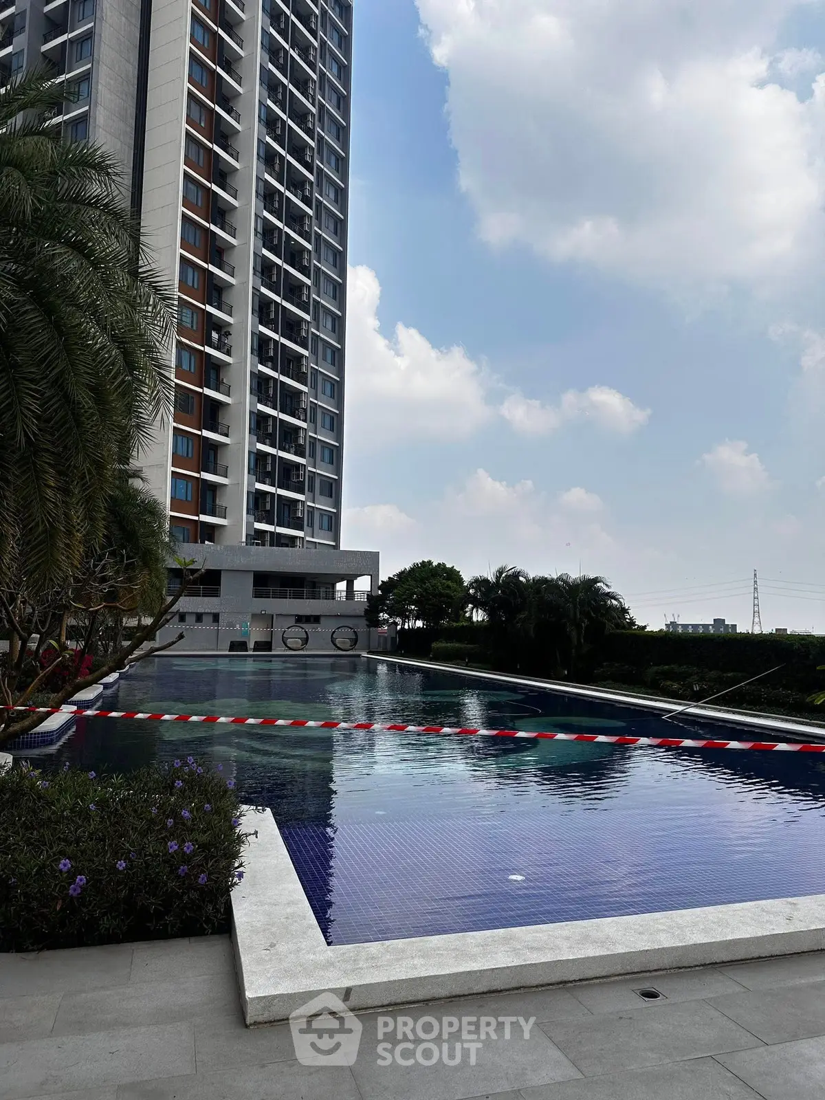 Luxurious high-rise building with stunning poolside view and lush greenery