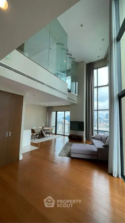 Luxurious high-ceiling living room with stunning city view and modern decor.