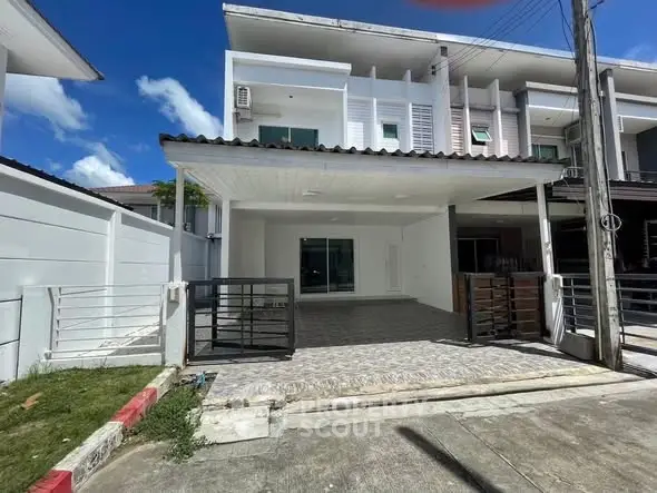 Modern townhouse exterior with spacious driveway and sleek design.