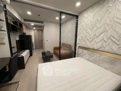 Modern bedroom with glass partition and stylish decor in a contemporary apartment.