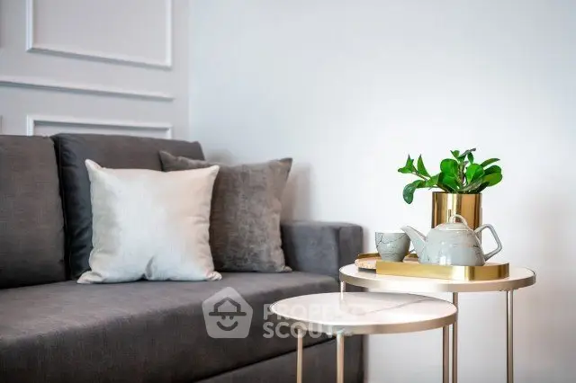 Stylish modern living room with elegant gray sofa and chic side tables.
