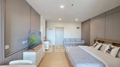 Spacious modern bedroom with stylish decor and cozy seating area