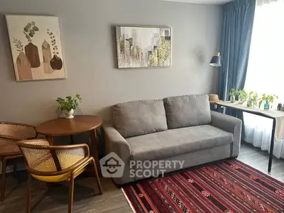 Cozy living room with modern decor, featuring a comfortable sofa, stylish chairs, and vibrant rug.