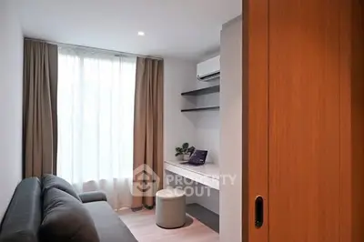 Modern study room with sleek desk and cozy sofa, perfect for productivity.