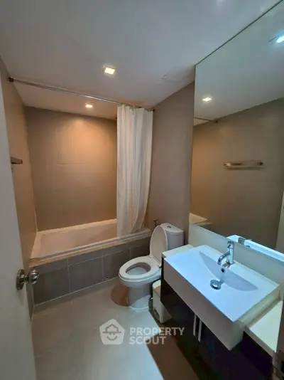 Modern bathroom with bathtub and sleek fixtures in a contemporary apartment.