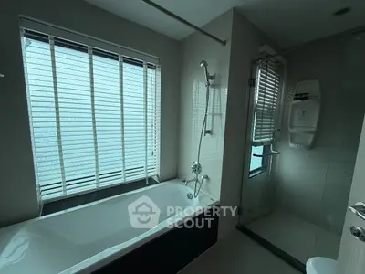 Modern bathroom with bathtub and glass shower enclosure