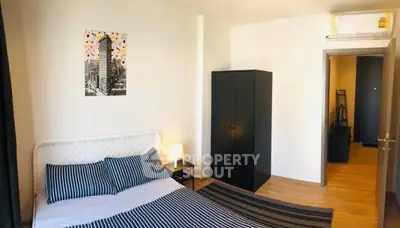Cozy bedroom with modern decor and striped bedding in a stylish apartment.