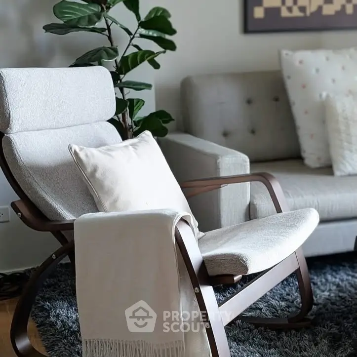 Stylish living room with modern armchair, cozy sofa, and lush plant decor.