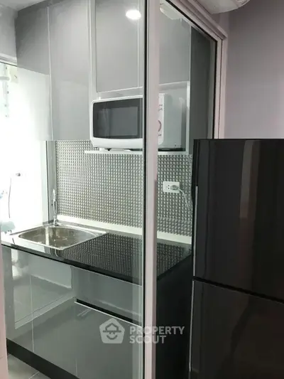 Modern compact kitchen with sleek appliances and stylish backsplash