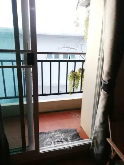 Charming small balcony with sliding glass door and cozy outdoor view.