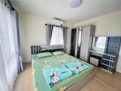 Cozy bedroom with modern furniture and floral bedding, featuring ample natural light and stylish decor.