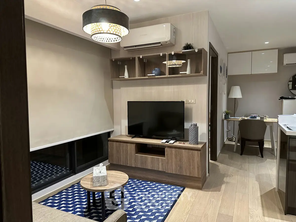 Modern living room with stylish decor and open layout, featuring a cozy seating area and sleek entertainment center.