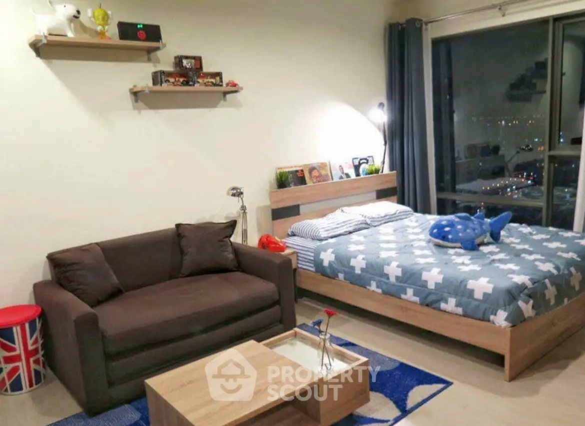 Cozy bedroom with modern decor and city view, featuring a comfortable bed and stylish sofa.