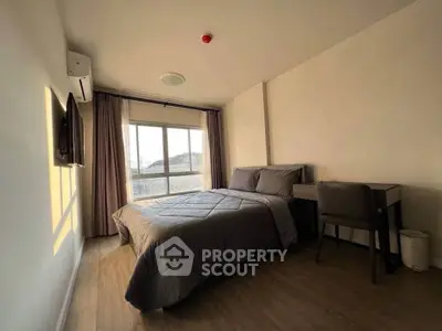 Cozy bedroom with natural light, featuring a comfortable bed and a work desk, perfect for relaxation and productivity.