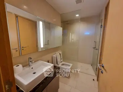 Modern bathroom with glass shower and sleek fixtures in a contemporary apartment.
