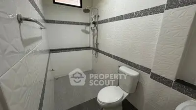 Modern bathroom with sleek white tiles and shower area