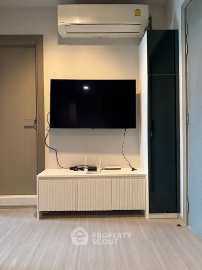 Modern living room with wall-mounted TV and air conditioning unit, featuring sleek minimalist design.