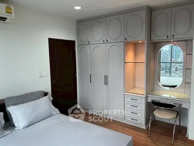 Stylish bedroom with built-in wardrobe and city view from window.