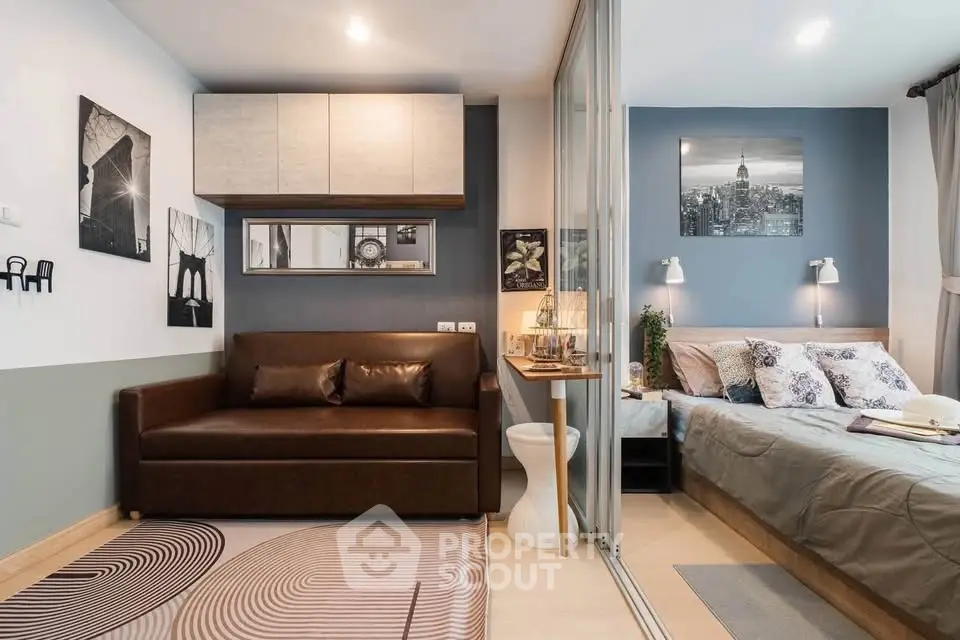 Modern studio apartment with stylish decor, featuring a cozy living area and a comfortable bedroom separated by glass.