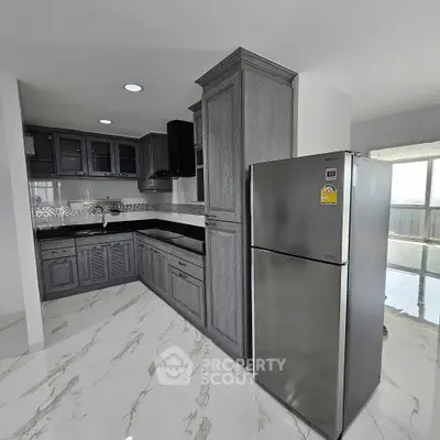 Modern kitchen with sleek cabinetry and stainless steel fridge in a bright open layout.