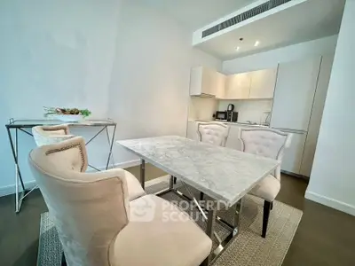 Modern dining area with elegant marble table and plush chairs in a stylish open kitchen layout.