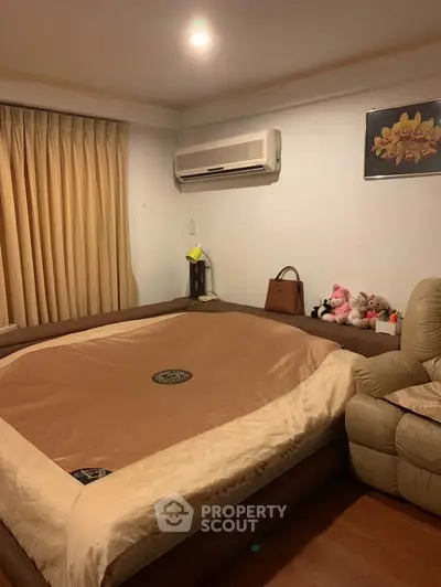 Cozy bedroom with plush bedding and air conditioning, perfect for relaxation.
