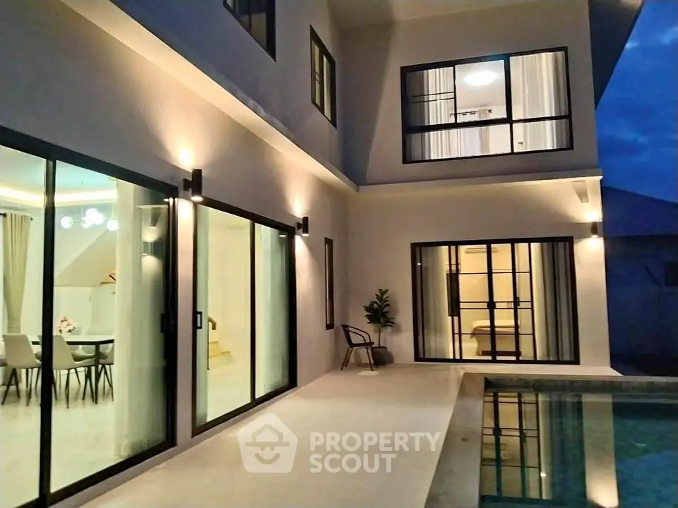 Modern luxury home with poolside view and elegant interior lighting.