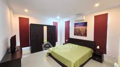 Spacious bedroom with modern decor and air conditioning, featuring a large wardrobe and stylish lighting.