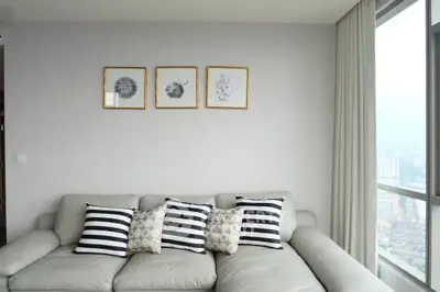 Modern living room with stylish sofa and city view through large windows