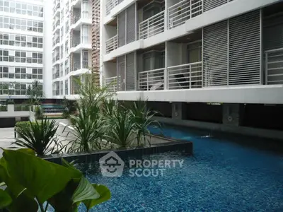 Modern apartment complex with a luxurious swimming pool and stylish architecture.