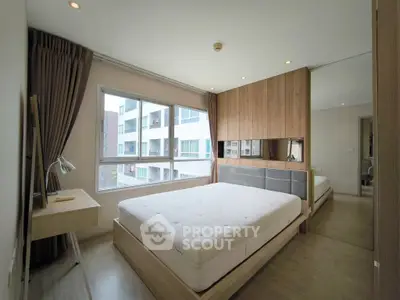 Spacious modern bedroom with large window and stylish wooden decor