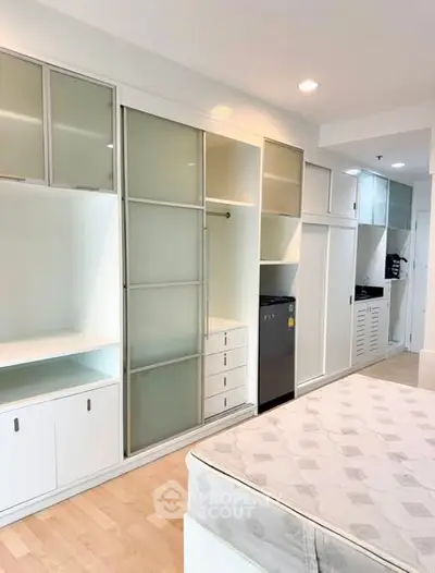Modern bedroom with built-in storage and sleek design in a contemporary apartment.