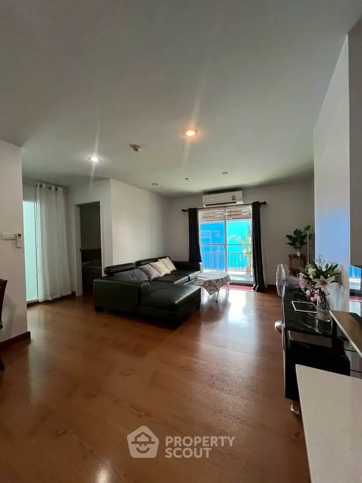 Spacious living room with modern decor and balcony access in a stylish apartment.