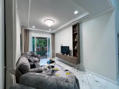 Luxurious living room with plush seating and elegant decor, featuring a modern entertainment center and garden view.