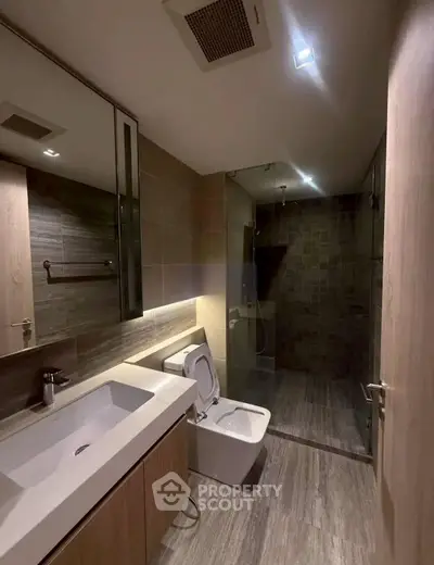 Modern bathroom with sleek design, featuring a glass shower and stylish vanity.