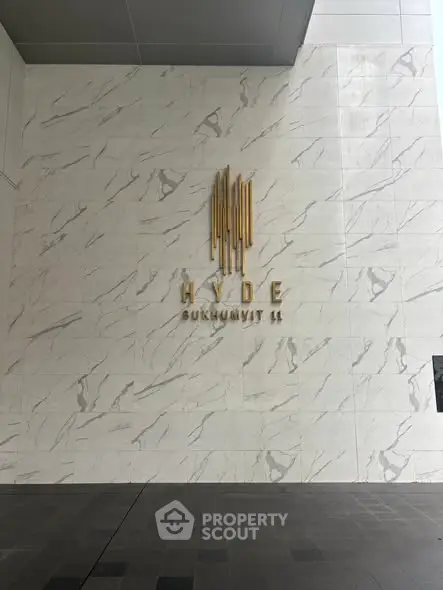 Elegant entrance of Hyde Sukhumvit 11 with modern marble wall design.
