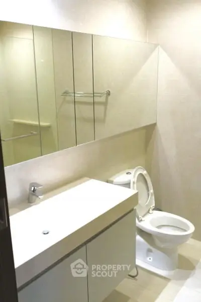 Modern bathroom with sleek fixtures and mirrored cabinets in a contemporary apartment.