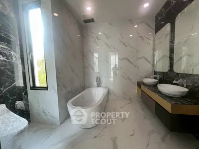 Luxurious modern bathroom with marble walls and freestanding bathtub