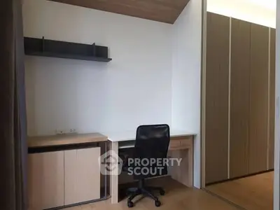 Modern study room with sleek desk, chair, and built-in storage in contemporary home.