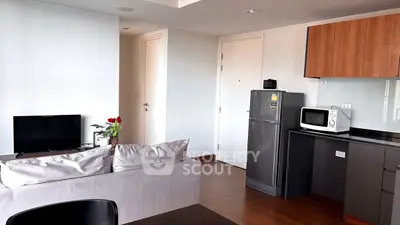 Modern apartment interior with sleek kitchen and cozy living area, featuring stylish furniture and appliances.