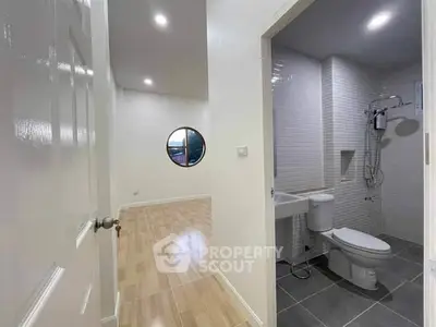 Modern bathroom with adjacent room, sleek design and bright lighting